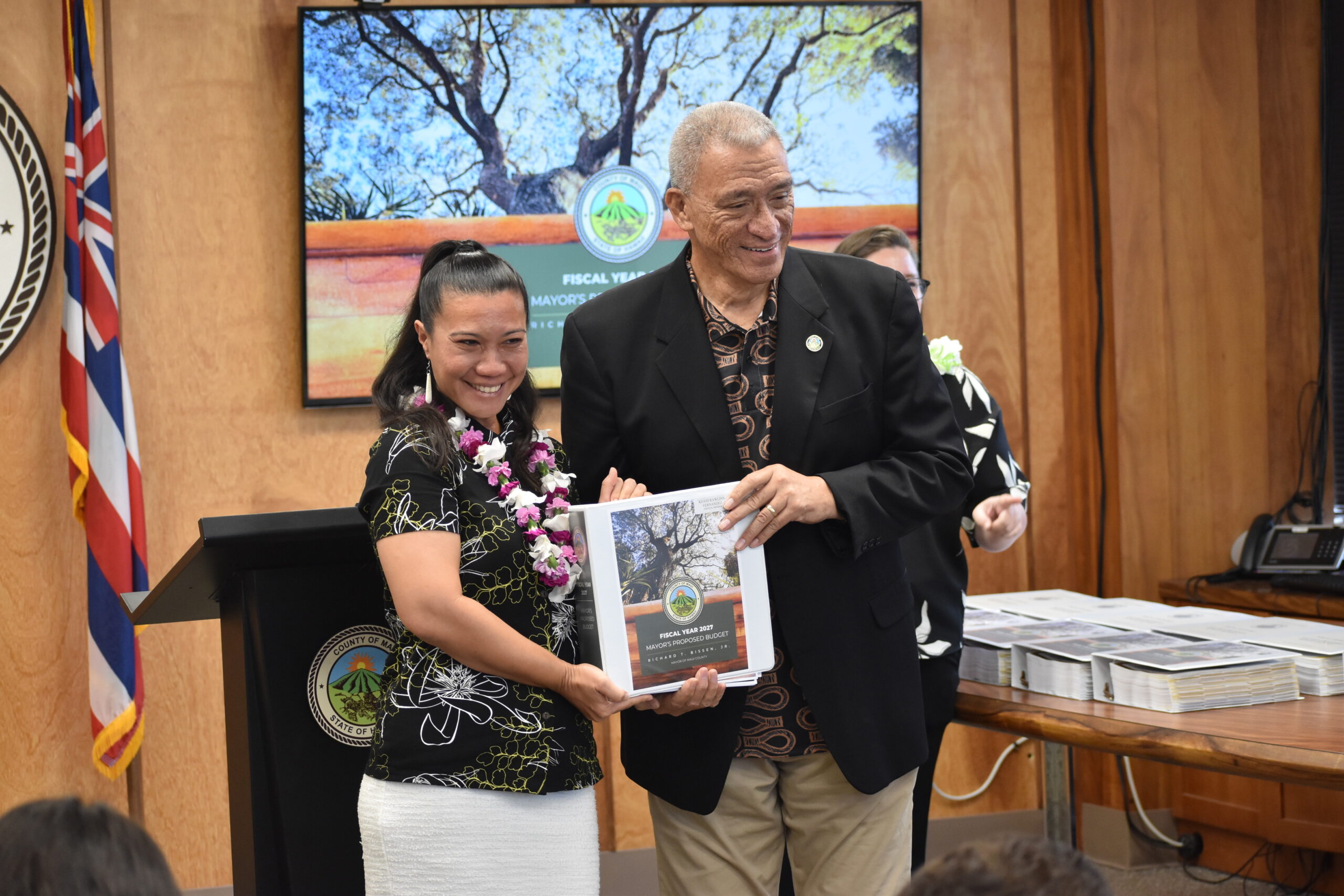 Councilmember Rawlins-Fernandez is handed a copy of the FY 2027 Mayorʻs Proposed Budget.