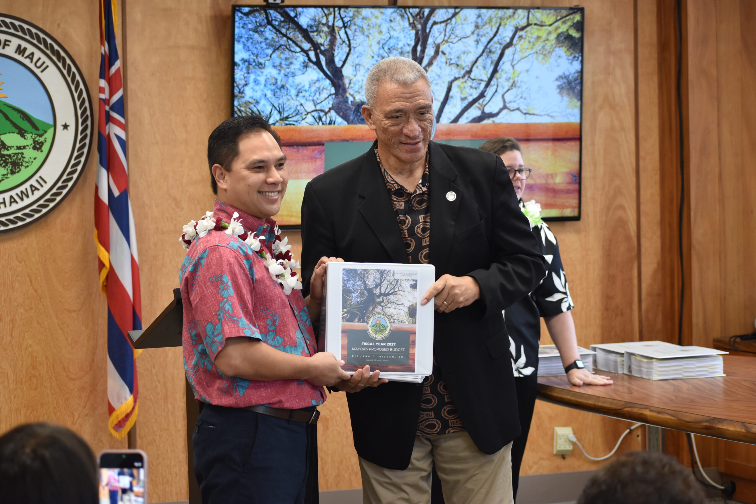 Councilmember Batangan is handed a copy of the FY 2027 Mayorʻs Proposed Budget.  